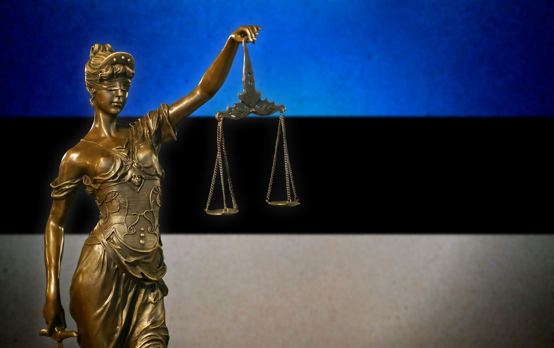 Lady Justice before an Estonian flag